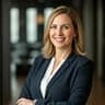 Professional woman with a confident smile in a modern office setting with natural light